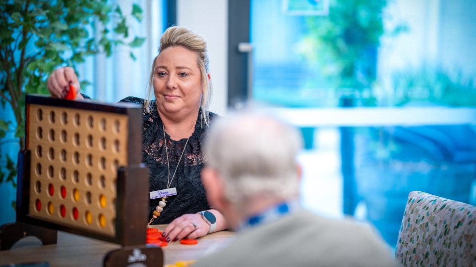 CAREERS Lifestyle Coordinator playing a game with a resident in a residential aged care home