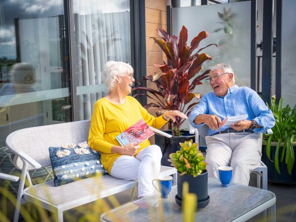 Residents at Peninsula View apartments enjoying their outdoor balcony and having a laugh