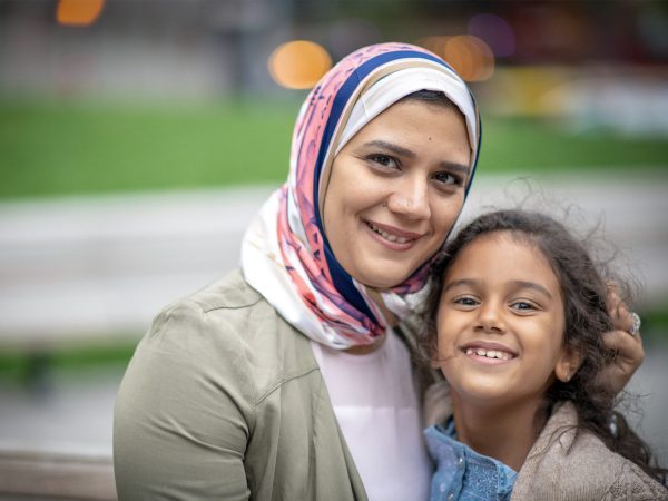 Happy mother seeking asylum with her daughter looking at the camera